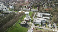 Man sieht das "Colani Ei" in Lünen, das in einem Industriegebiet steht. Es sind einige Autos und Gebäude drum herum zu sehen. 