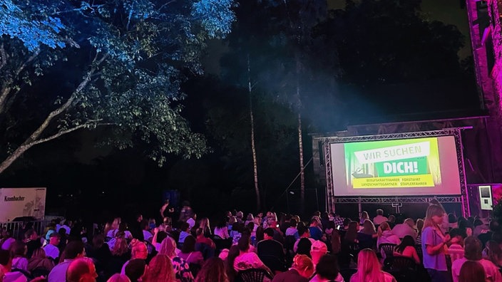 Zuschauer sitzen am Abend im Open-Air-Kino Siegen und warten auf den Filmbeginn.