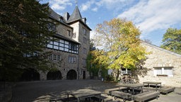 Außenansicht von Burg Blankenheim. Vorne stehen Tische und Bänke.