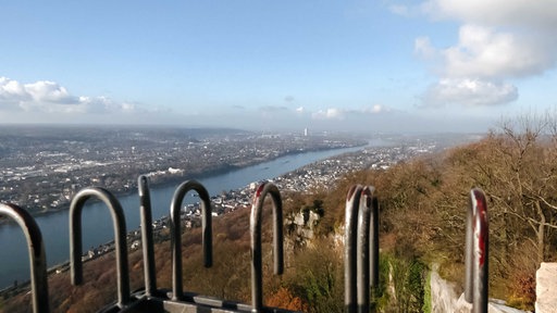 Blick vom Drachenfels über eine Metallbrüstung auf den Rhein und das Rheintal