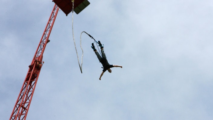 Ein Mann springt von einem Bungee-Turm