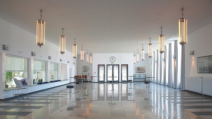 Eine helle Empfangshalle mit großen Fenstern