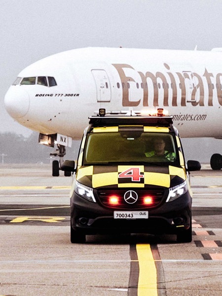 David Schönemann am Steuer des Follow-Me-Cars, im Hintergrund ein großes Flugzeug