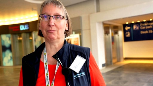 Ute Clevers steht vor dem Gebäude des Düsseldorfer Flughafens