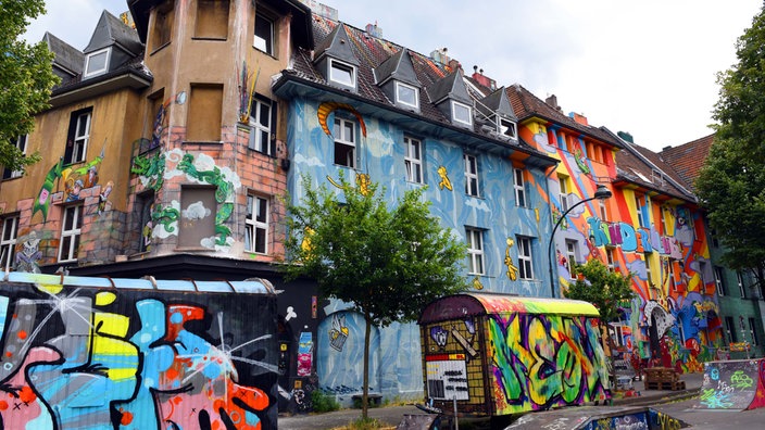 Bemalte Wohnhäuser und Bauwagen stehen in der Kiefernstraße in Düsseldorf-Flingern