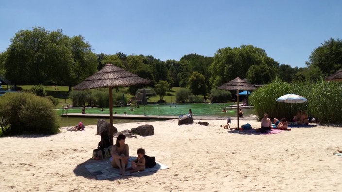 Badegäste am Sandstrand des Naturfreibads Mettmann.