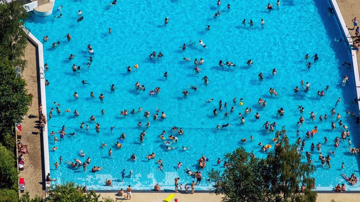 Das Becken mit Badegästen des Freibads Selbachpark in Hamm von oben.