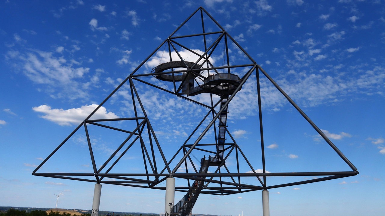 Die pyramidenförmige Stahlskulptur Tetraeder in Bottrop vor blauem Himmel