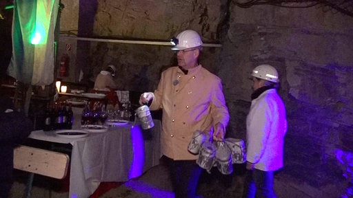 Ein Mann mit Helm bringt Essen an einen Tisch