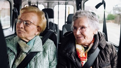 Maria Lauscher und Anneliese Hallmann sitzen in einem kleinen Bus