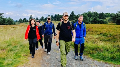 Menschen wandern durch die Heide.