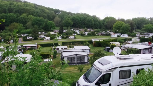 Campingplatz Hohensyburg mit Blick auf ein Wohnmobil, dahinter zahlreiche Zelte und Wohnmobile auf einer Grünfläche verteilt