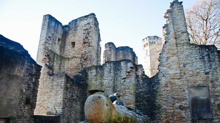 Burgruine aus Stein mit unterschiedlich hohen Türmen und Zinnen