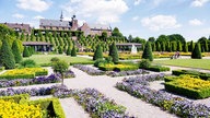 Bunt bepflanzte Beete mit der Kloster Kamp im Hintergund.