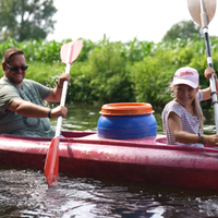 Ein Mädchen und ihr Vater paddelnd auf einem Fluss.