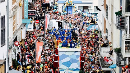 Rosenmontagszug in Köln. Viele Zuschauer stehen am Rand.