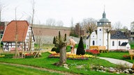 Modellnachbauten von Rietberger Dörfern auf dem Gelände der Landesgartenschau. Ein Mann schaut sich die Ausstellung an.