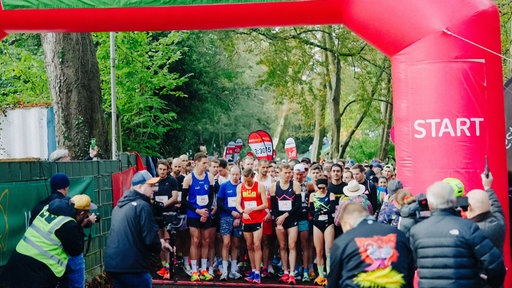 Teilnehmende eines Marathons stehen an der Startlinie.