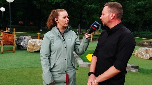 Der Betreiber der Adventure-Golf-Anlage spricht in ein WDR-Mikrofon