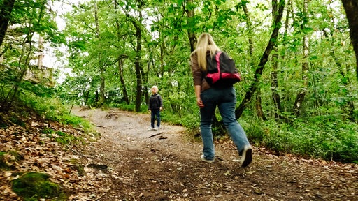 Aren und Mutter Melina Krause laufen einen Waldweg hoch.