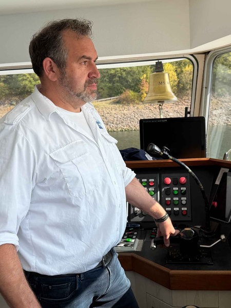 Frank Harnischmacher steht im Steuerhaus der EMS Westfalen und steuert das Schiff