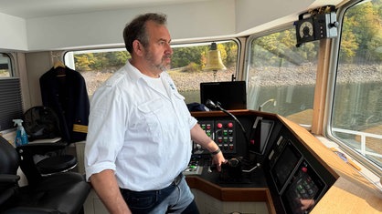Frank Harnischmacher steht im Steuerhaus der EMS Westfalen und steuert das Schiff