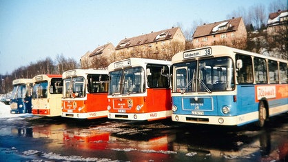 Farbenfrohe, alte Busse in Beige, Rot und Blau