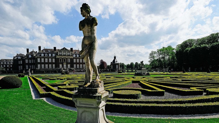 Der Blick vom Schlosspark auf das Schloss Nordkirchen, im Vordergrund eine Skulptur.