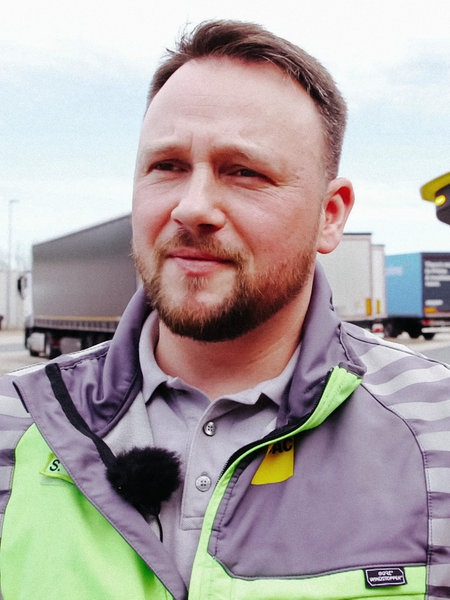 ADAC-Pannenhelfer Stefan Sonnemann steht auf einem Autobahn-Rastplatz.