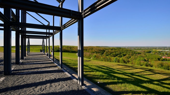 Der Ausblick von der Halde Norddeutschland auf den Niederrhein. Außerdem sind Stahlträger der Installation "Hallenhaus" links im Bild