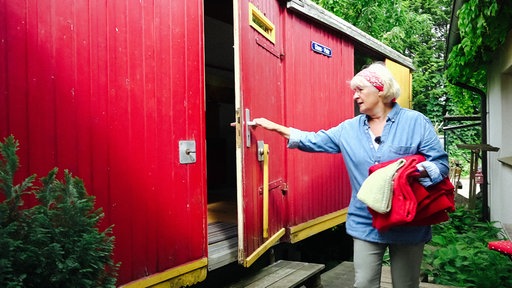 Petra Deutsch sitzt in ihrem Bauwagen und lächelt in die Kamera.