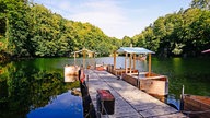 Ein Bootssteg führt auf den blauen See in Ratingen.