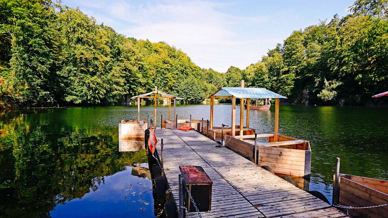 Ein Bootssteg führt auf den blauen See in Ratingen.