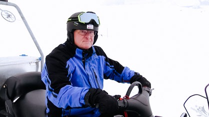 Achim Lepperhof, ein älterer Mann, trägt einen Helm und dicke Winterkleidung.