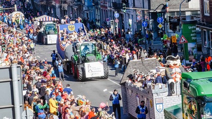 Der Rosenmontagszug in Aachen. Traktoren ziehen Wagen.