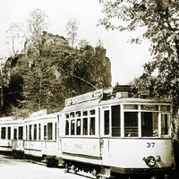 Ein altes Bild einer Straßenbahn, die zwischen den Externsteinen hindurch fährt.