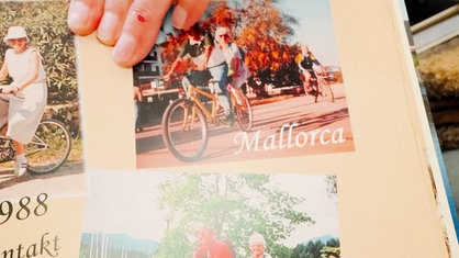 Ein Fotoalbum mit Bildern von einem Urlaub auf Mallorca zeigt ein Paar auf einem Tandem