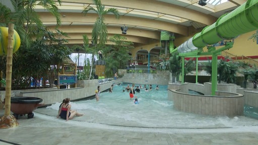 Im Schwimmbecken schwimmen und spielen Menschen