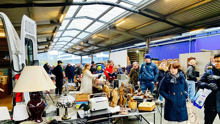 Viele Menschen besuchen einen Trödelmarkt.