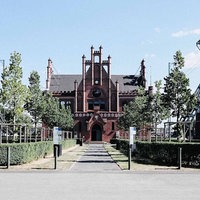 Frontalansicht Zeche Zollern. Ein rotes Backsteingebäude mit spitzem Dach und vielen Verzierungen.