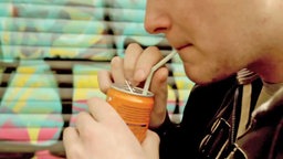 Nahaufnahme: Junger Mann trinkt Softdrink aus Flasche