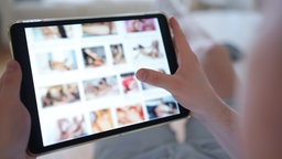 Porno-Internetseite auf einem Tablet (gestellte Szene) - immer mehr Frauen und Mädchen werden Opfer von Deepfake-Pornos