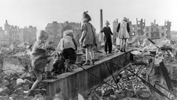 Das Beitragsbild des WDR3 Kulturfeature "Es war Frieden. Was würden wir daraus machen?" zeigt spielende Kinder in den Trümmern einer Stadt, 1946.