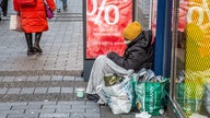 Das Beitragsbild des Dok5 "Angst haben fast alle" zeigt eine obdachlose Person in Decken gehüllt vor einem Schaufenster in der Fußgängerzone.