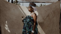 Eine Voodoo-Eingeweihte posiert für ein Porträt im Mami Wata-Tempel in Ouidah, 2025.