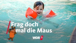 Mädchen mit Schwimmflügeln und nassen Haaren im Pool