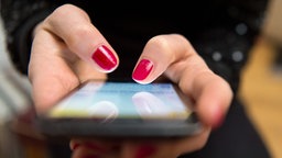 Eine Frau tippt auf einem Smartphone