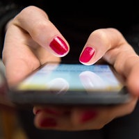Eine Frau tippt auf einem Smartphone
