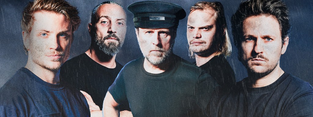 Eine Insel im Meer, das Wetter ist düster und regnerisch. Die Schauspieler zu sehen: Bjarne Mädel, Jannik Schümann, Dimitrij Schaad, Wilson Ochsenknecht, Murathan Muslu.