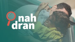 Ein Kind umarmt einen Mann. Links das Logo von nah dran